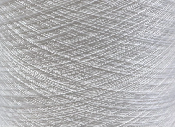 Primo piano di filato di cashmere bianco, intrecciato con precisione per garantire una qualità superiore.