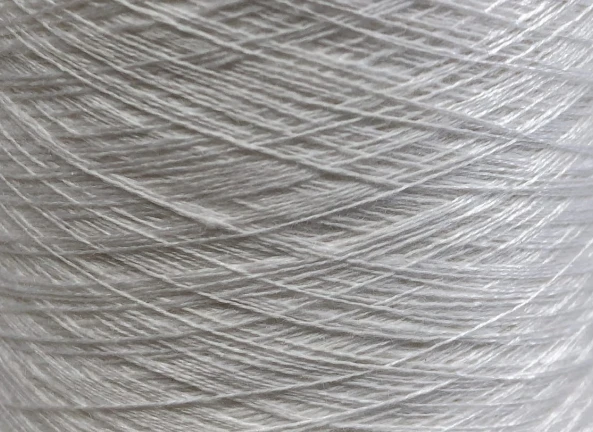 Filato di lino bianco, intrecciato con precisione, ideale per la miscelazione con la fibra di cashmere.