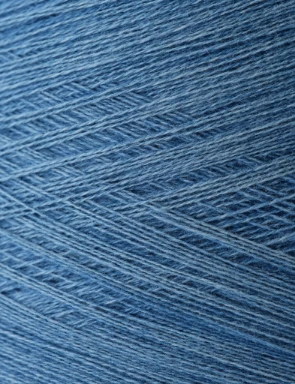 Dettaglio di filato tinto in blu utilizzando tecniche di tintura vegetale ecocompatibile, ispirate alla tradizione e supportate da tecnologie moderne.