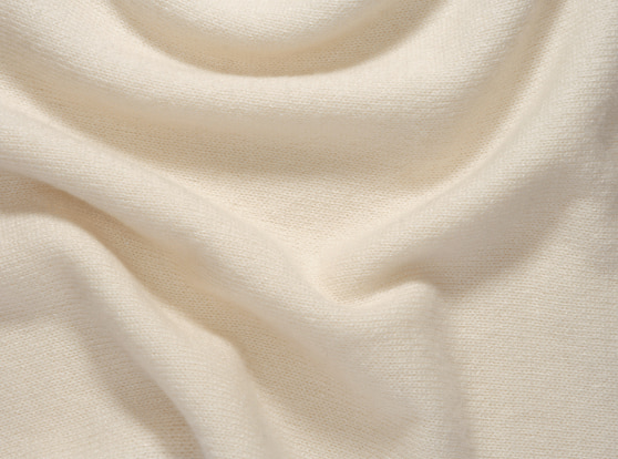 Tessuto morbido in cashmere pettinato, con una finitura elegante e uniforme.