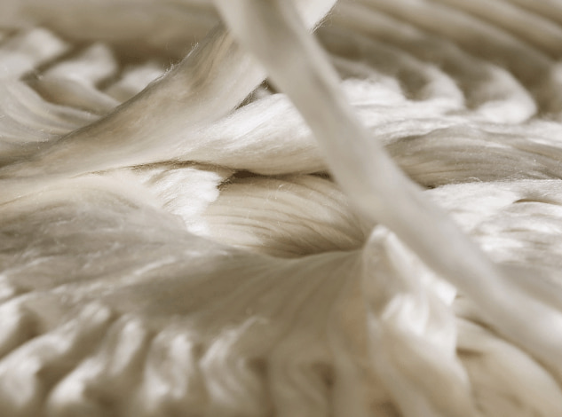 Dettaglio di fibra di filato pettinato in fase di lavorazione, che mette in risalto la sua morbidezza e lucentezza naturale.