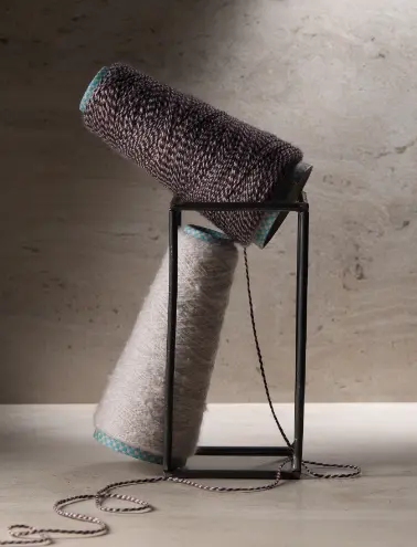Coni di filato cashmere Cariaggi® in esposizione, che evidenziano la qualità artigianale e la varietà di colori disponibili.