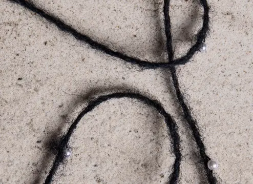 Filato decorativo nero con dettagli di perle bianche, ideale per aggiungere un tocco di eleganza ai capi.